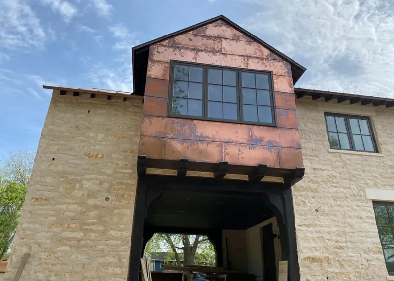 Copper metal panel facade on a stone building for Skylight Installation in Dracut